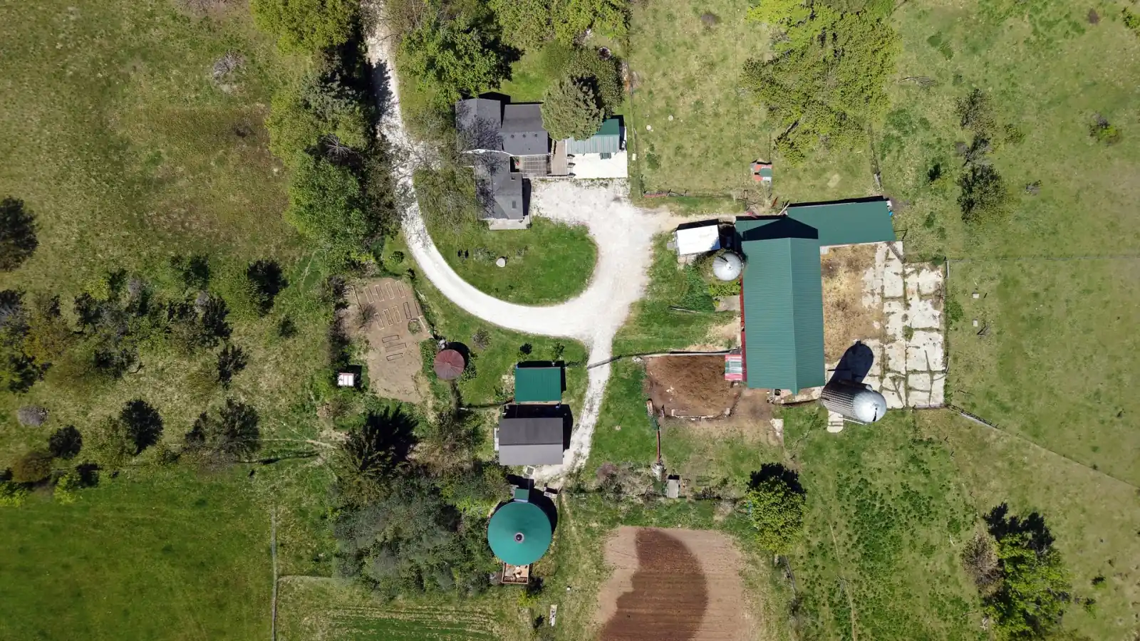 Top-down aerial of the Goldstein Farm farmstead: farmhouse, circular drive, barn, silos and yurt, Spring Prairie, Wisconsin