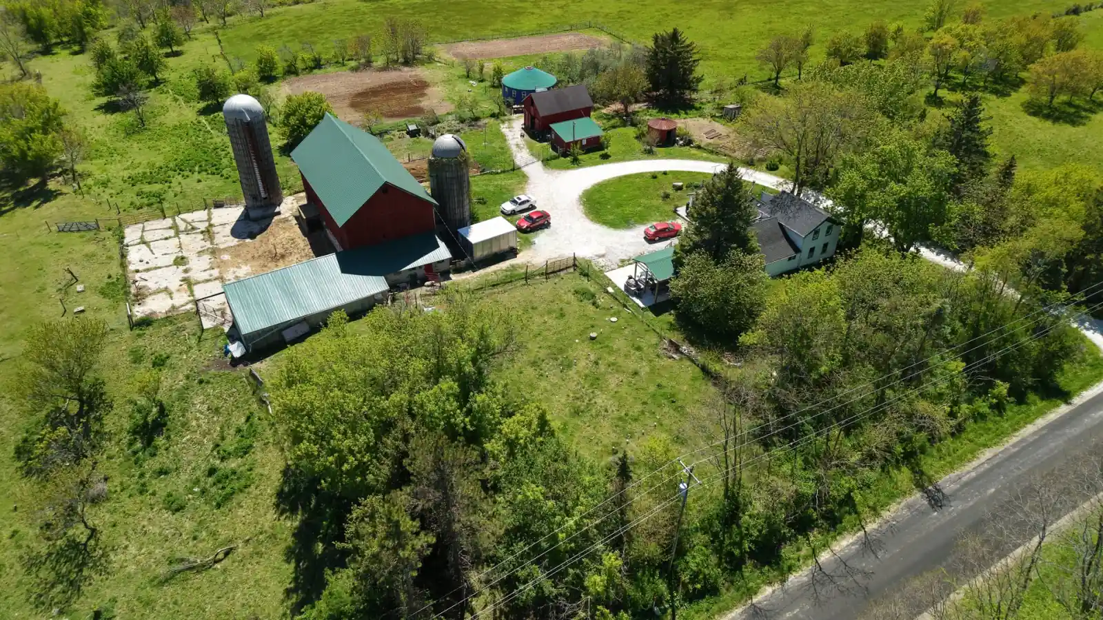 Close aerial of the red barn with two silos, the 1900 farmhouse and the circular drive at the Goldstein Farm, Walworth County, Wisconsin