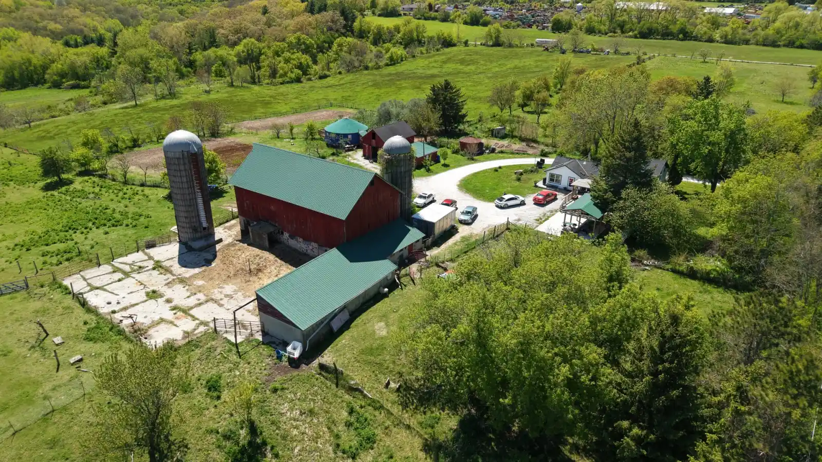 Red timber-frame barn with green roof and two silos at the Goldstein Farm near Lake Geneva, Wisconsin