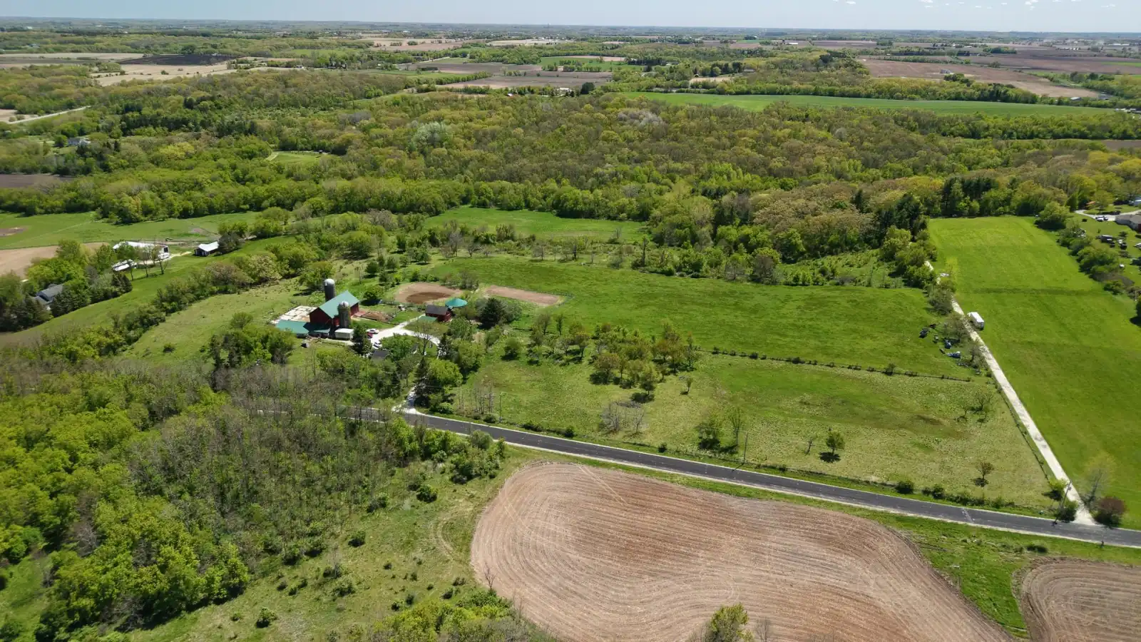 Wide aerial of rolling Spring Prairie countryside in Walworth County, Wisconsin, with the Goldstein Farm in the middle distance